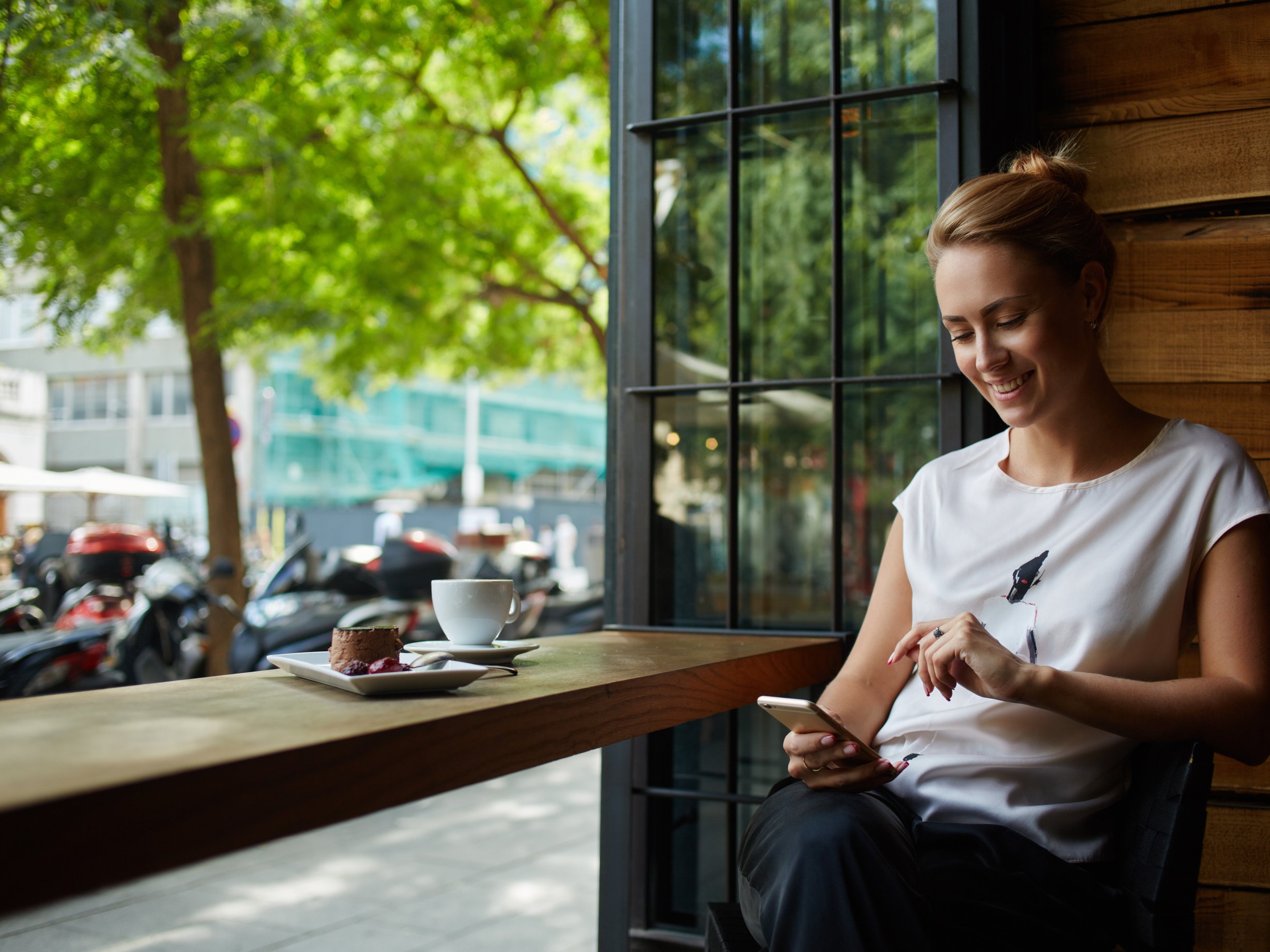 Kundin checkt in einem Café ihr Smartphone