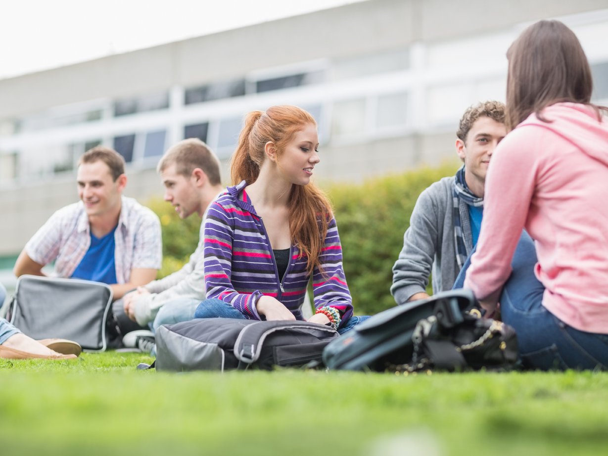 Student:innen sitzen auf Wiese